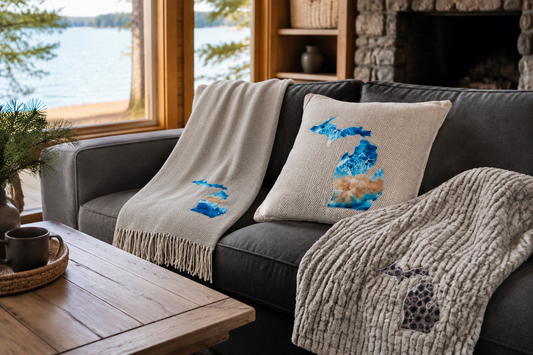 CloudSoft herringbone throw with fringe and Michigan appliqué draped on a cabin sofa, with coordinating pillows and faux fur.